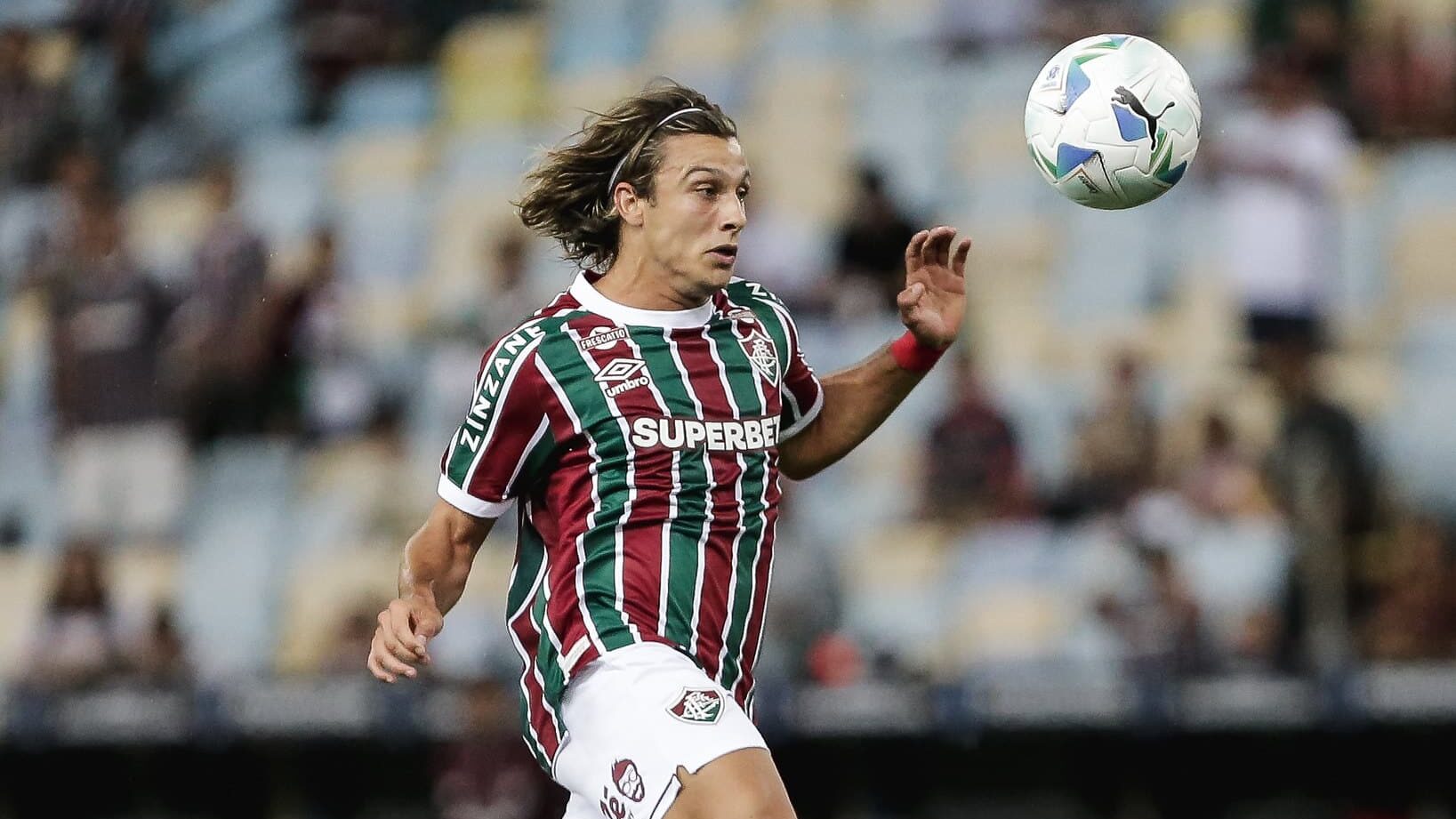 O jogador Canobbio corre olhando para a bola, que está no ar